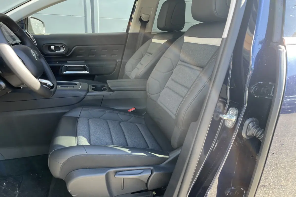 Vue intérieure côté conducteur du Citroën C5 Aircross bleu eclipse, mettant en valeur les sièges advanced comfort et l'accoudoir central.