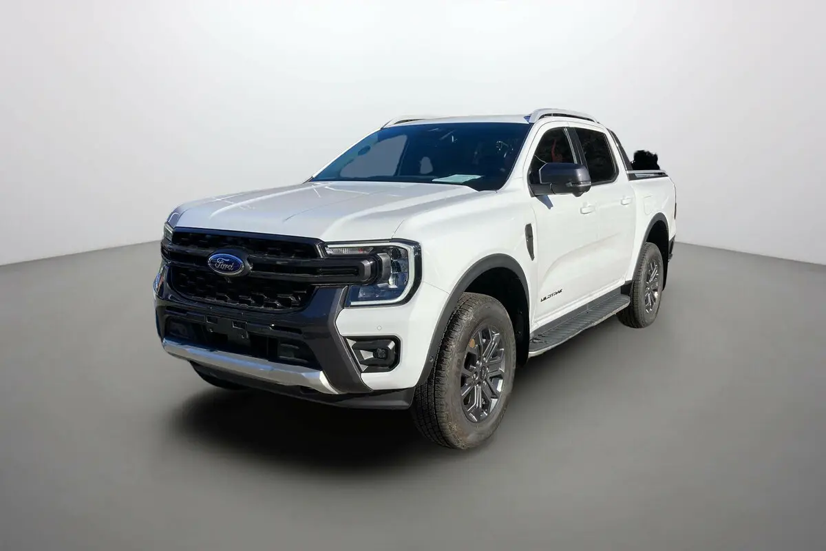 Ford Ranger 2025 blanc glacier en vue 3/4 avant droit avec calandre noire et jantes foncées Wildtrak Plus.