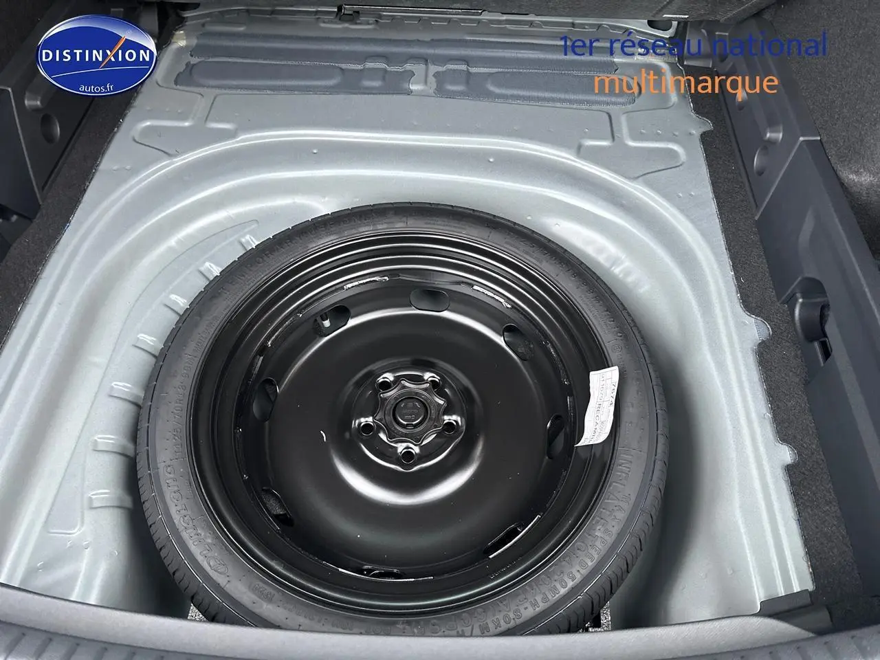 Vue plongeante sur la roue de secours noire dans le coffre gris magnétique d'une CUPRA LEON ST 1.5 etsi hybrid 2025.