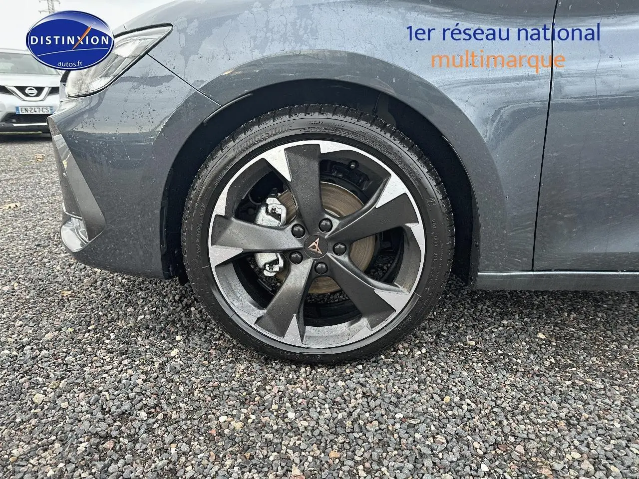 Gros plan sur la roue avant gauche d'une CUPRA LEON ST gris magnétique, avec jante alu au design sportif.