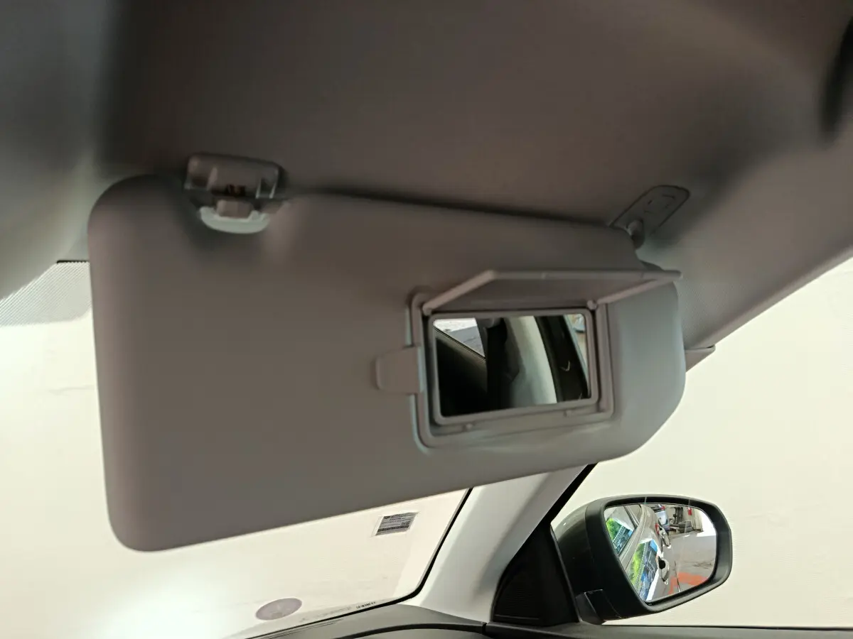 Miroir de courtoisie ouvert sur le pare-soleil côté gauche dans l’habitacle gris clair du Peugeot 3008 2020.