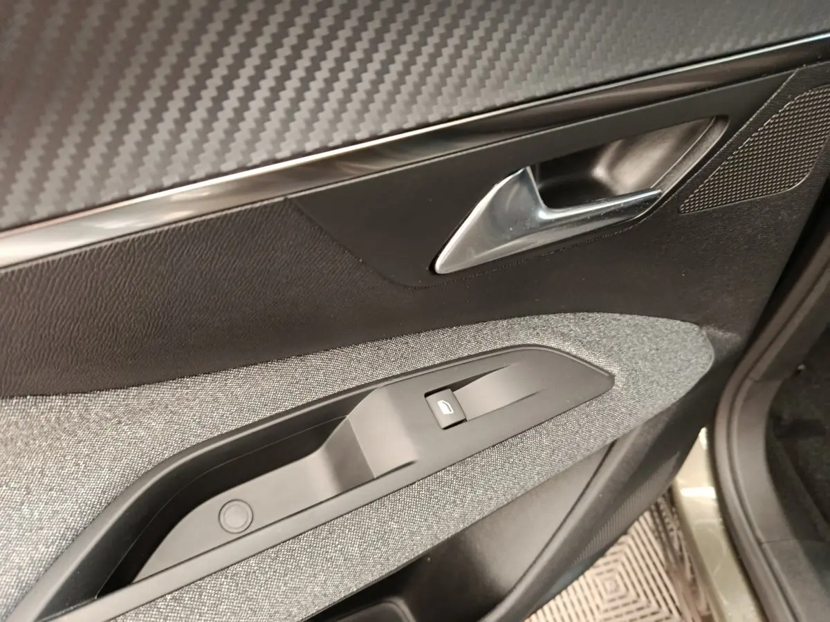 Détail de la porte côté conducteur du Peugeot 3008 gris foncé, montrant la poignée et le bouton de verrouillage électrique.