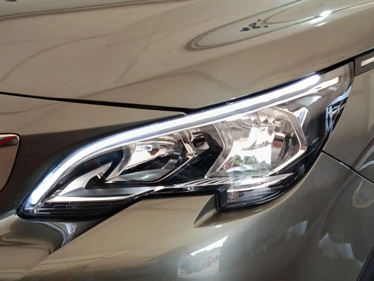 Gros plan sur le phare avant droit du Peugeot 3008 gris foncé, mettant en valeur son design LED distinctif.