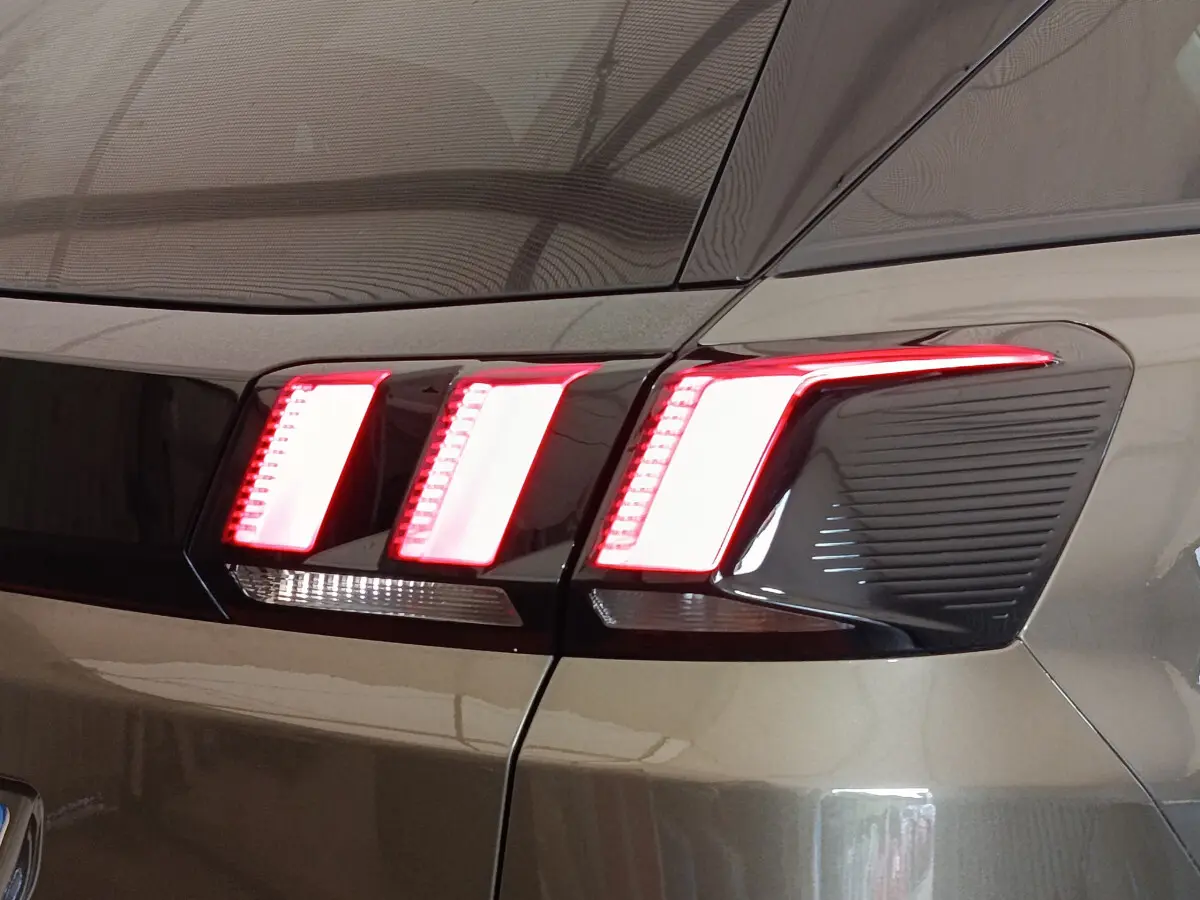 Gros plan sur le feu arrière droit rouge et blanc du Peugeot 3008 gris foncé, version Puretech 130 S&S Active Business.