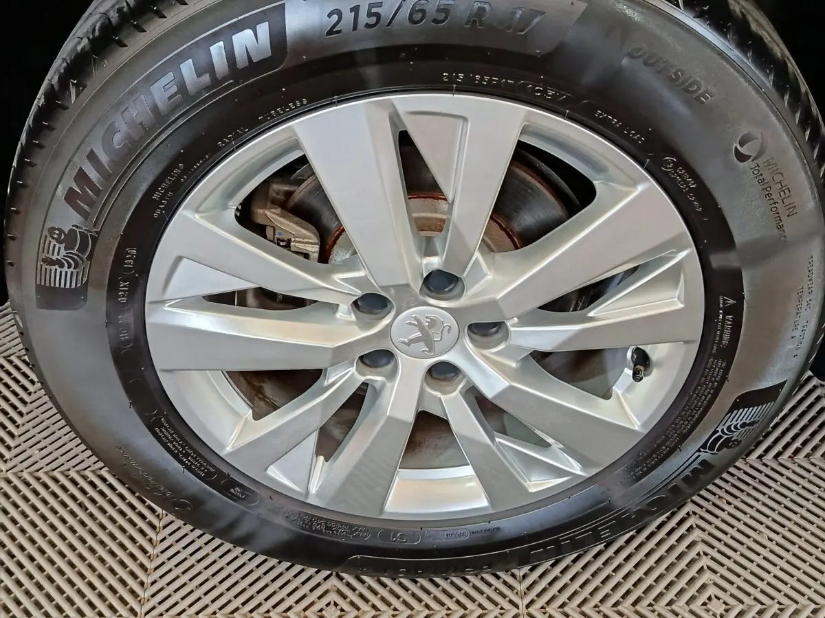 Gros plan sur la jante alliage argentée et pneu Michelin du Peugeot 3008 gris foncé de 2020.