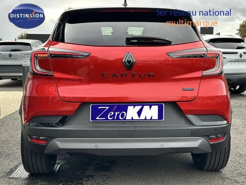 Vue arrière d'un Renault Captur 2025 hybride rouge Flamme avec détails noirs et logo Captur bien visible