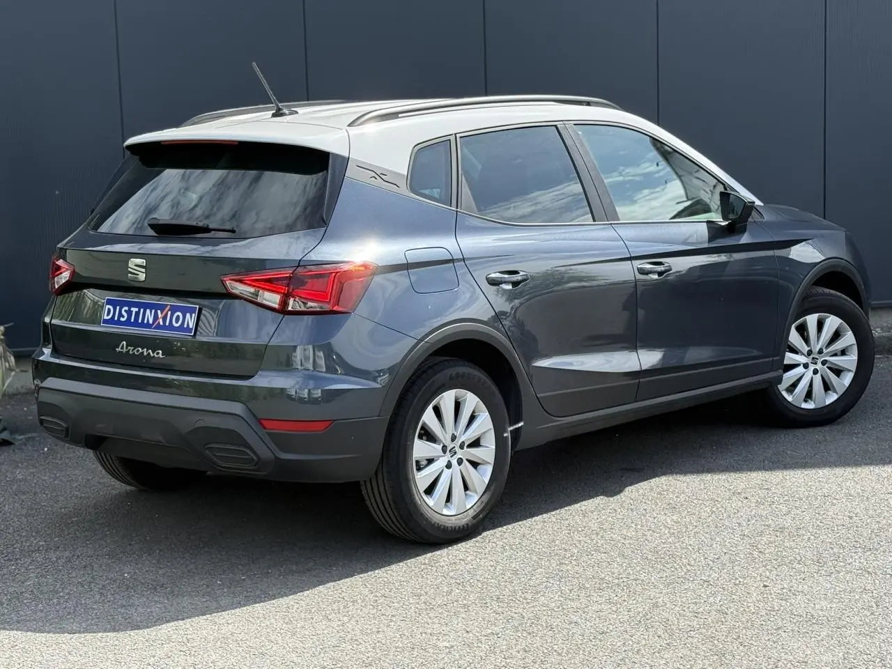 Vue 3/4 arrière droite d'un SEAT Arona 2025 gris magnétique avec toit blanc et jantes alliage 16 pouces.