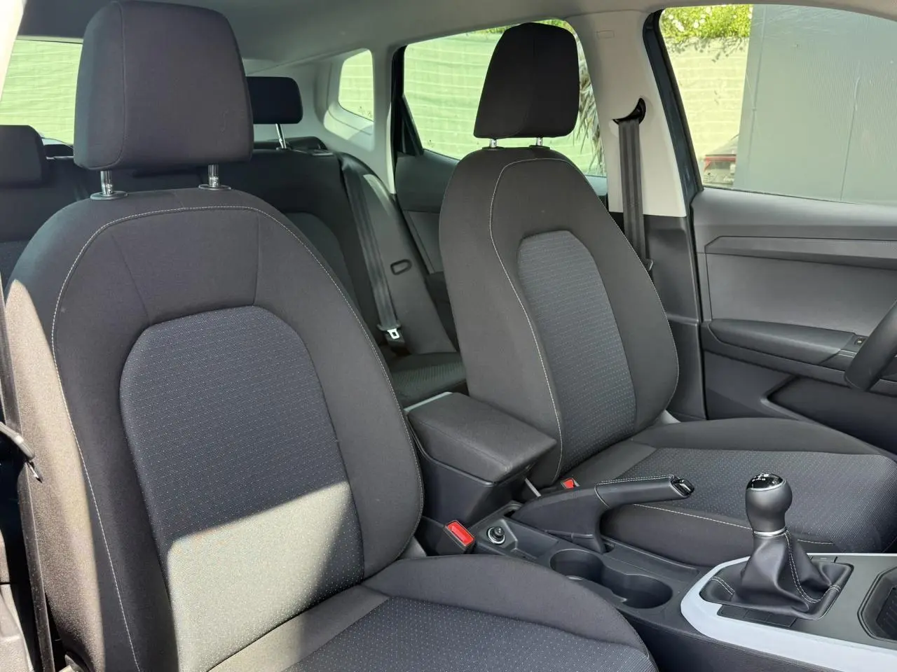 Vue intérieure des sièges avant noirs et console centrale avec levier de vitesse manuelle d'une SEAT Arona 2025.