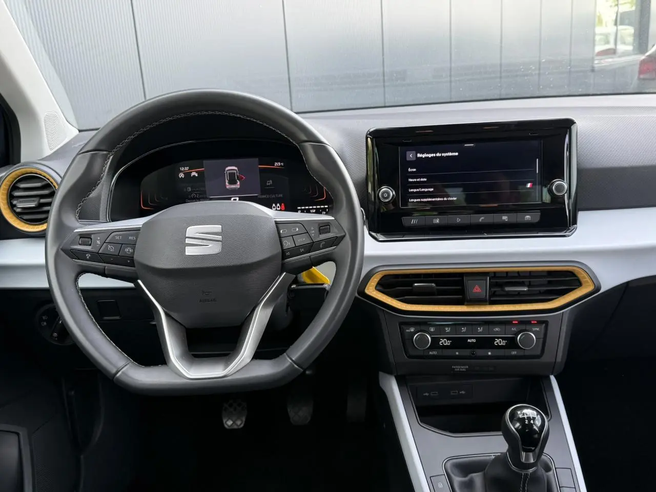 Intérieur SEAT Arona TSI 115 Style 2025 vu de face, volant multifonction, écran tactile et détails bois clair.