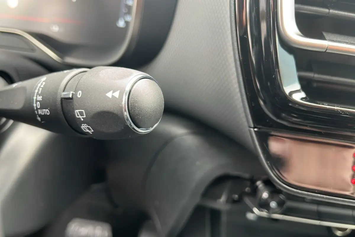 Gros plan sur la commande des essuie-glaces à gauche du volant dans l’habitacle du Citroën C5 Aircross blanc okénite.