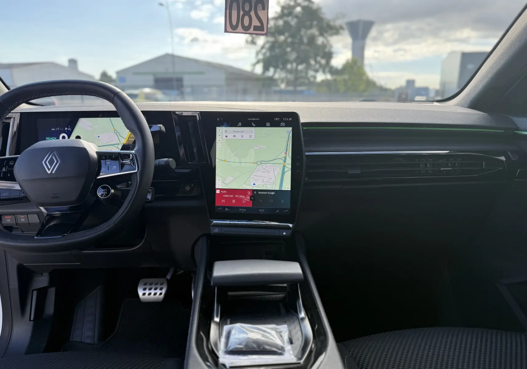 Vue intérieure frontale du tableau de bord du Renault Austral Hybrid avec écran tactile central et volant multifonction noir.