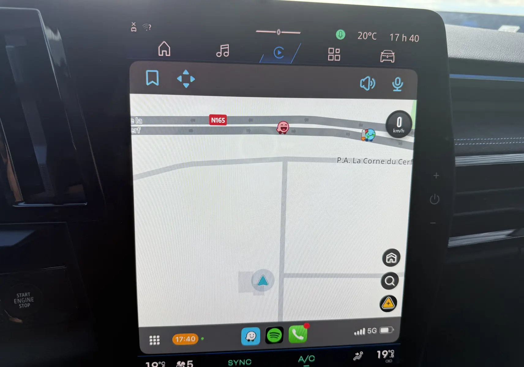 Écran tactile central du Renault Austral Hybrid 2025 montrant la navigation, avec tableau de bord noir et détails bleus.