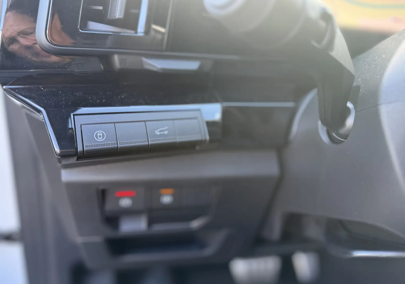 Détail intérieur du tableau de bord côté gauche du Renault Austral Hybrid 2025, boutons de verrouillage et ouverture coffre.