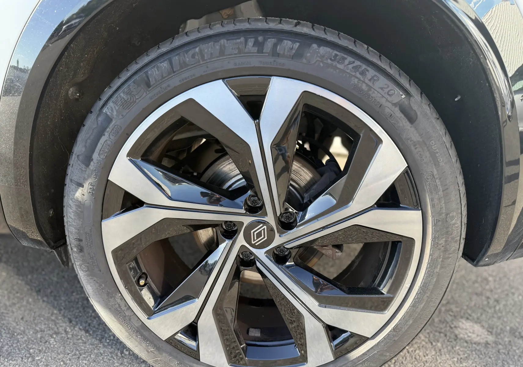 Gros plan sur la jante avant droite biton noire et argent du Renault Austral Hybrid 2025 avec pneu Michelin.