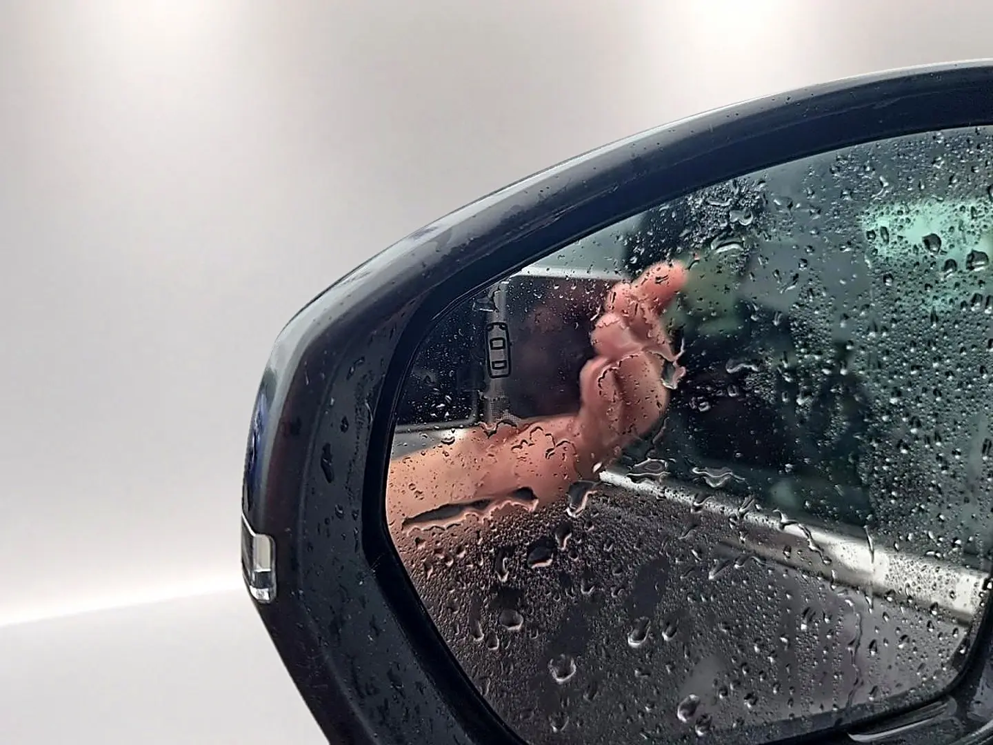 Rétroviseur droit gris de Citroën C5 Aircross 2025 avec gouttes d'eau et reflet partiel du véhicule.