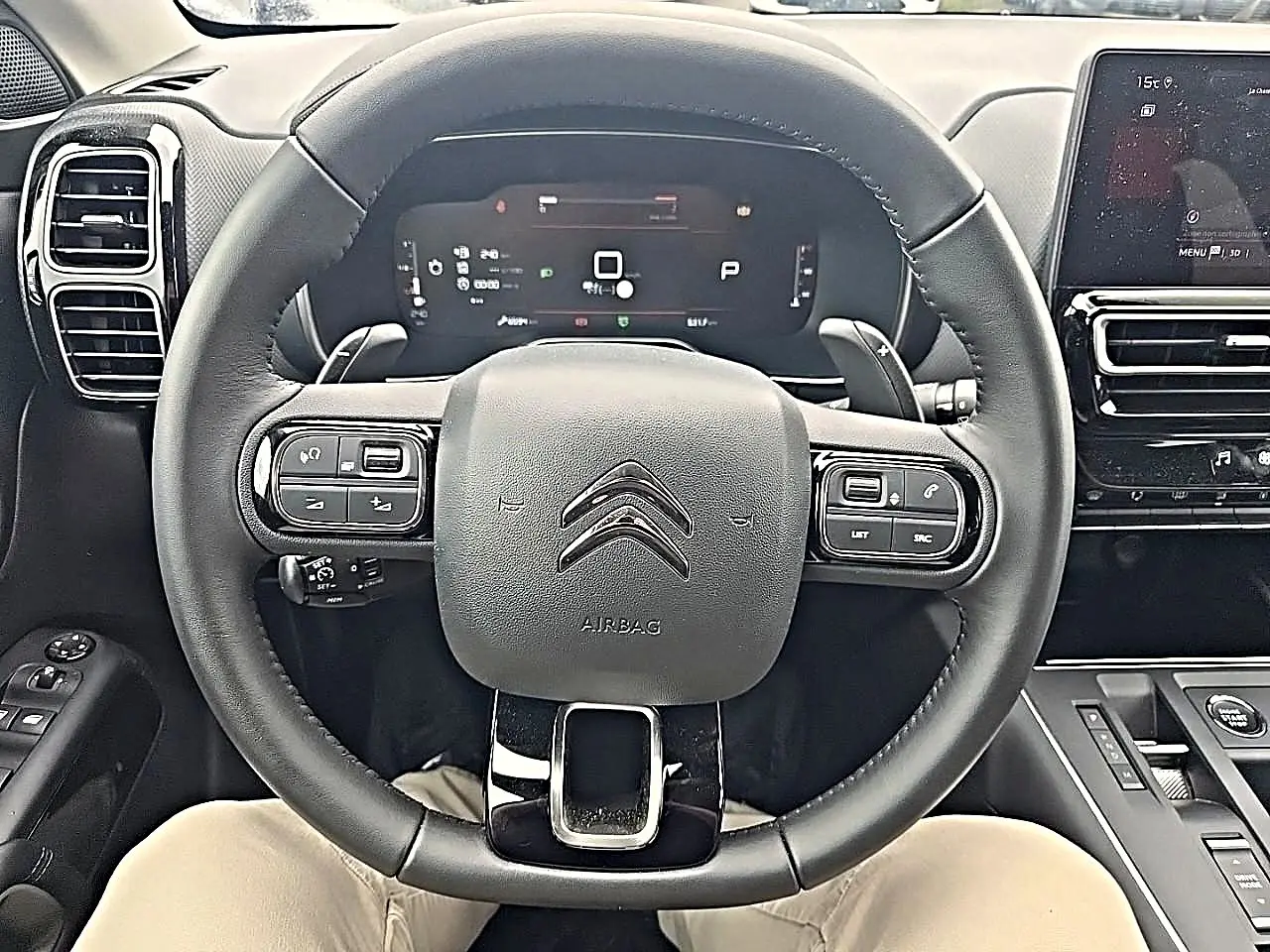 Vue rapprochée du volant cuir noir multifonction d’un Citroën C5 Aircross 2025 avec tableau de bord numérique et écran tactile.