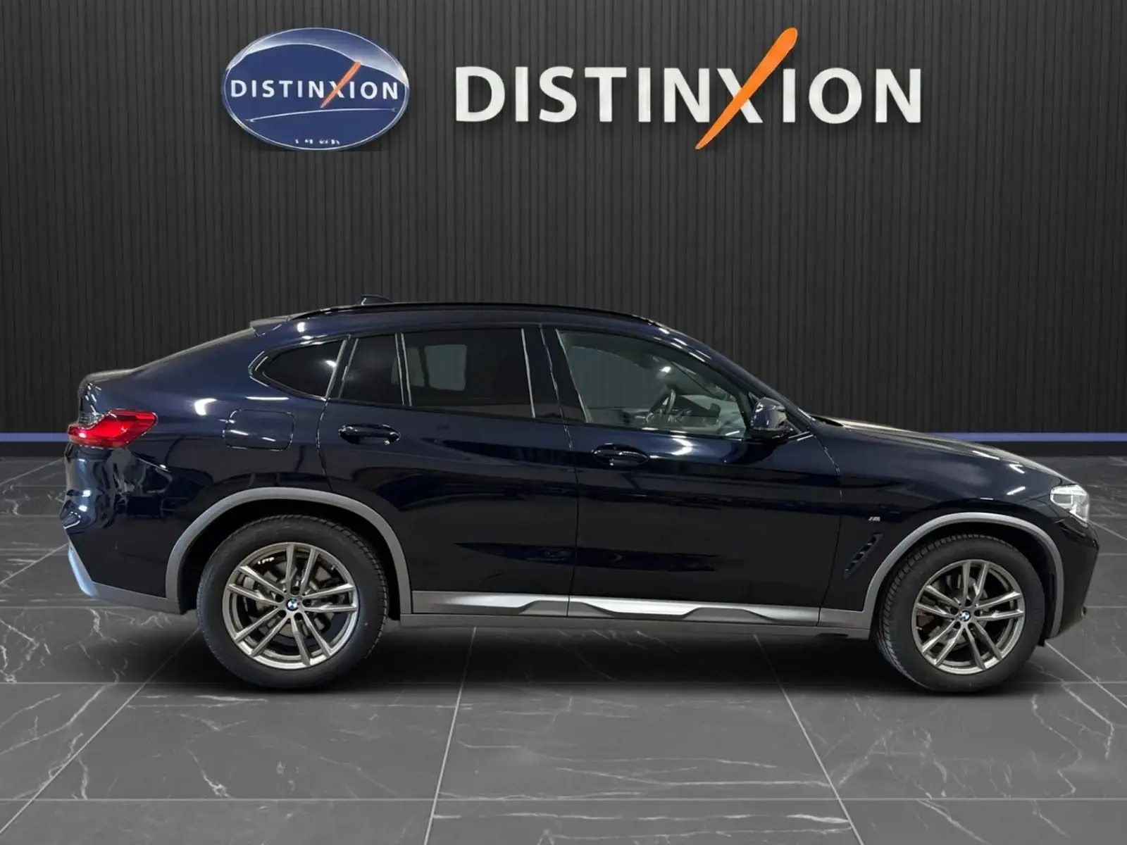 Profil côté gauche d'un BMW X4 XDrive 20d 2020 en Carbonschwarz, avec jantes alliage et lignes sportives M.