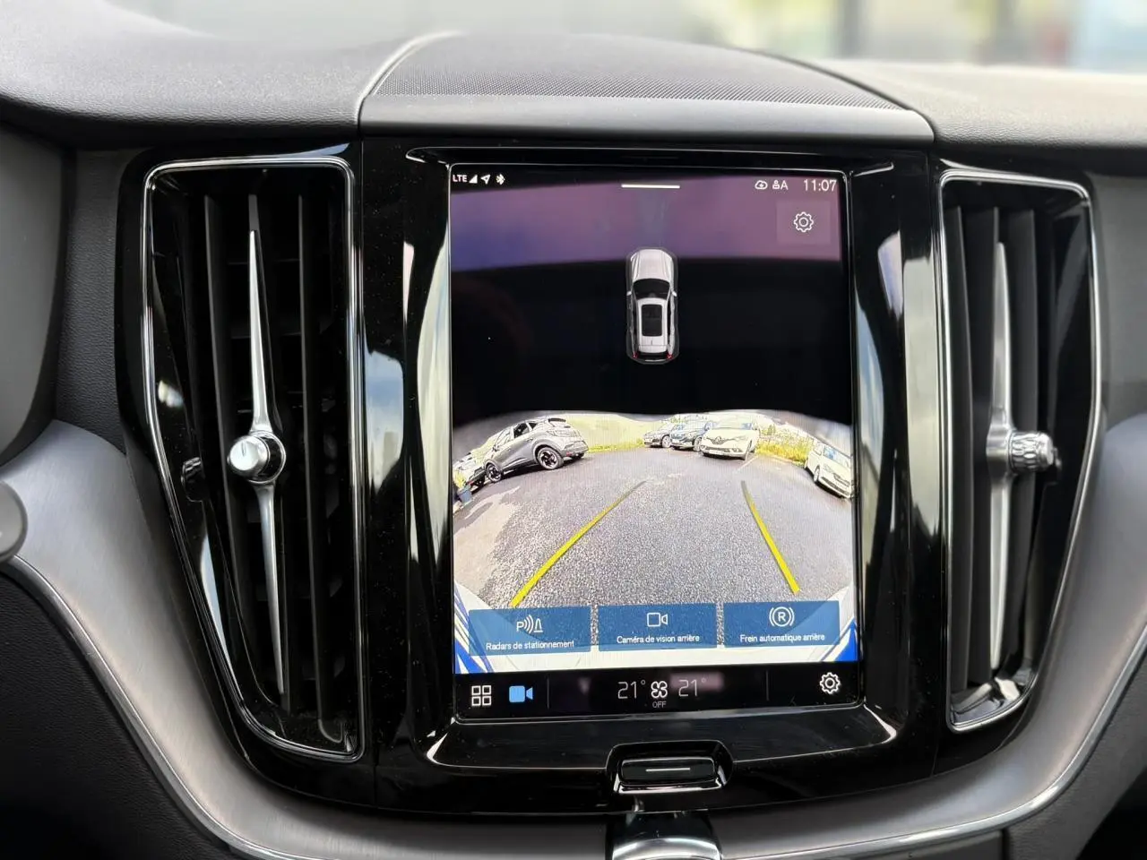 Écran tactile central du Volvo XC60 2024 affichant la caméra de recul et les radars de stationnement.