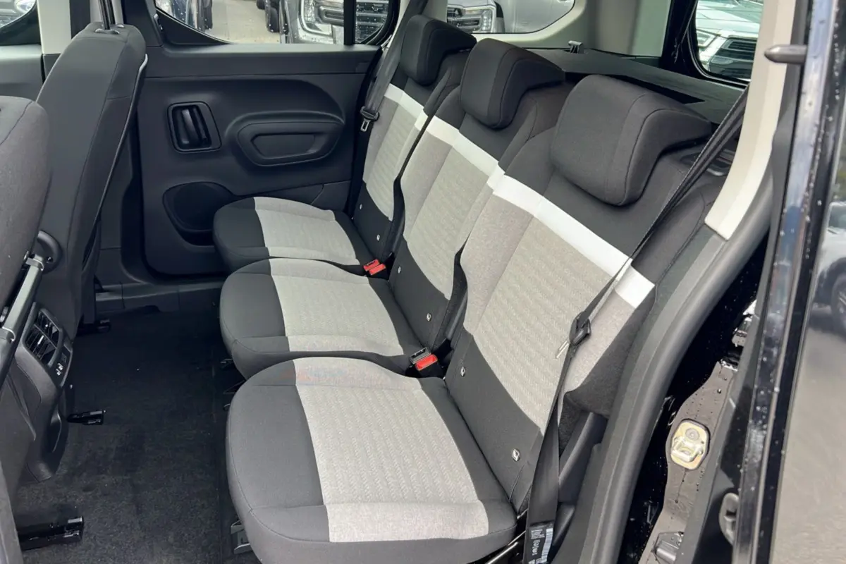 Vue latérale droite de l'intérieur arrière du Citroën Berlingo 2025 noir perla nera avec sièges tissu bicolore gris et noir.