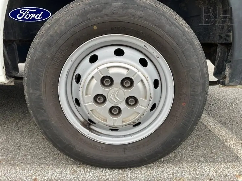 Gros plan sur la roue avant droite blanche Banquise d'un Citroën Jumper FGN 33 L2H2 2018 avec jante acier et logo Citroën.