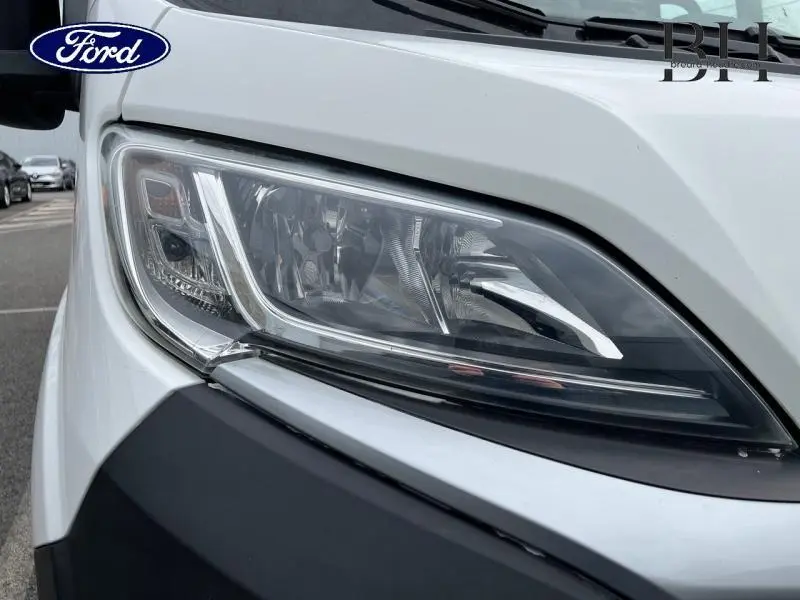 Gros plan sur le phare avant droit du Citroën Jumper blanc Banquise, soulignant ses lignes modernes et nettes.