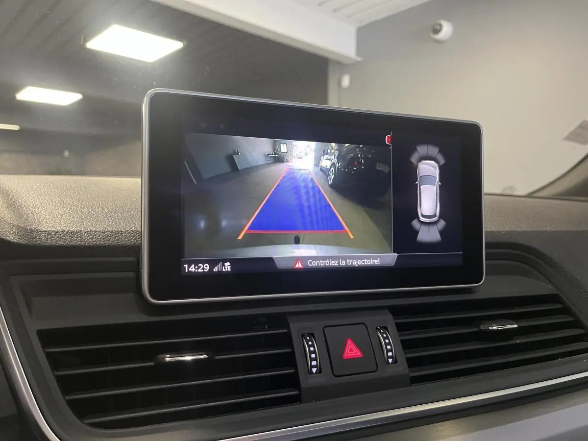 Écran central de l'Audi Q5 S line 2019 montrant la caméra de recul avec guidage de trajectoire en intérieur noir.