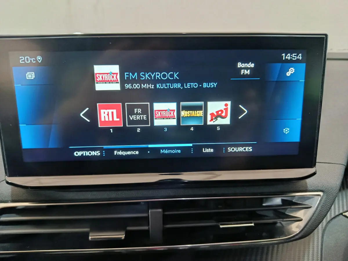 Écran tactile central 10 pouces du tableau de bord du Peugeot 3008 bleu, affichant les radios FM en intérieur.