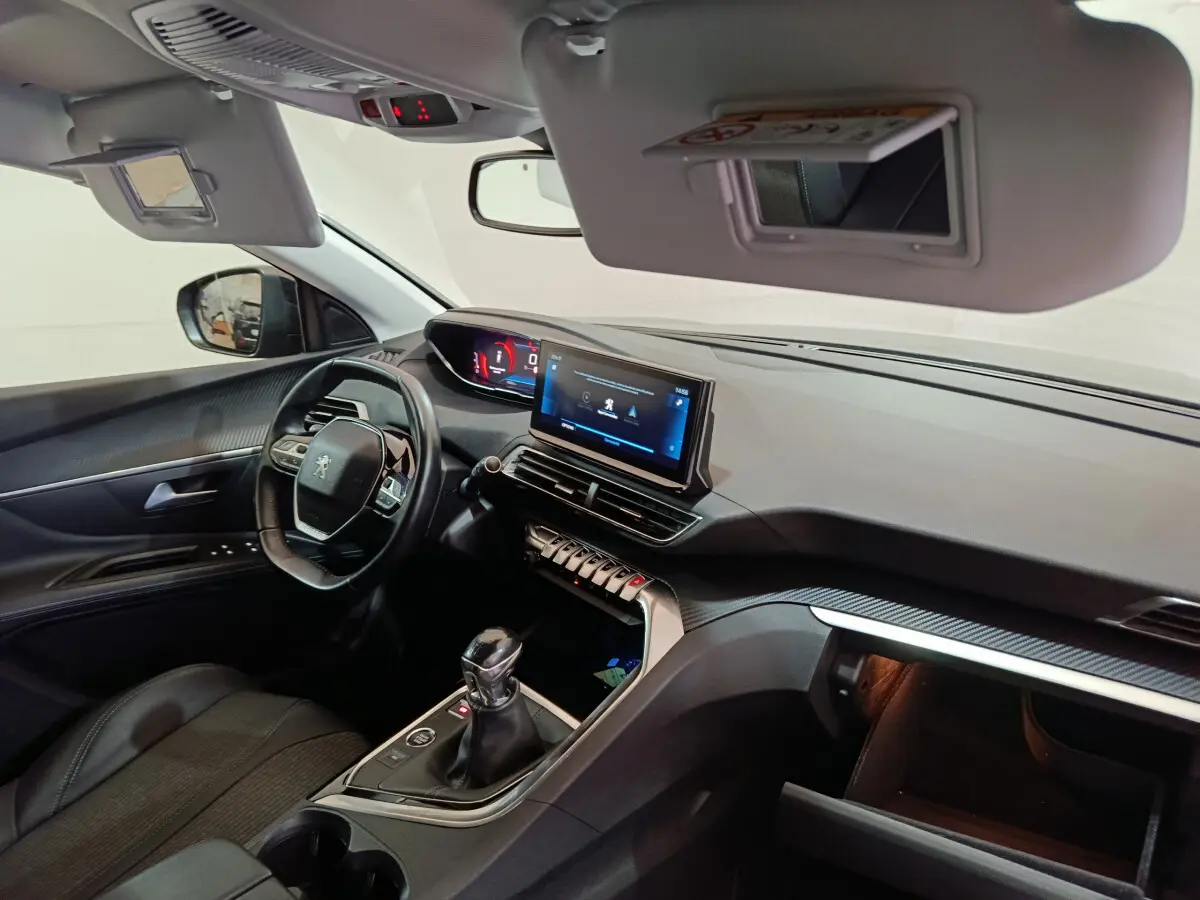 Intérieur du Peugeot 3008 bleu, vue côté conducteur, tableau de bord avec écran tactile et volant cuir multifonctions.