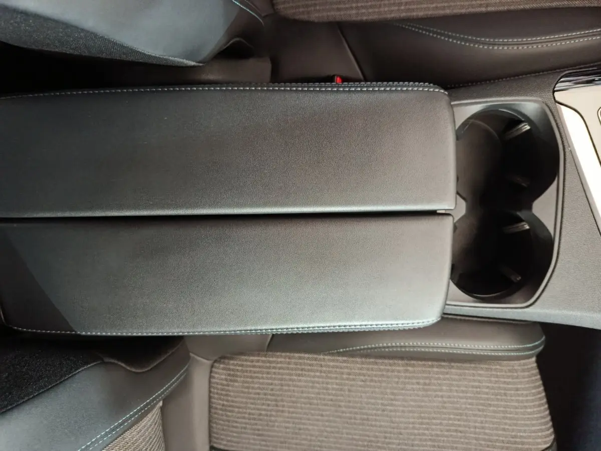 Vue rapprochée de l'accoudoir central noir et des porte-gobelets du Peugeot 3008 PureTech 130 S&S Allure 2022.
