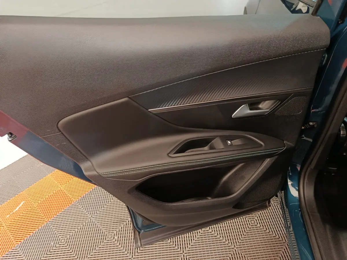 Vue côté gauche de la porte avant bleu du Peugeot 3008 avec garniture noire et insert effet carbone.