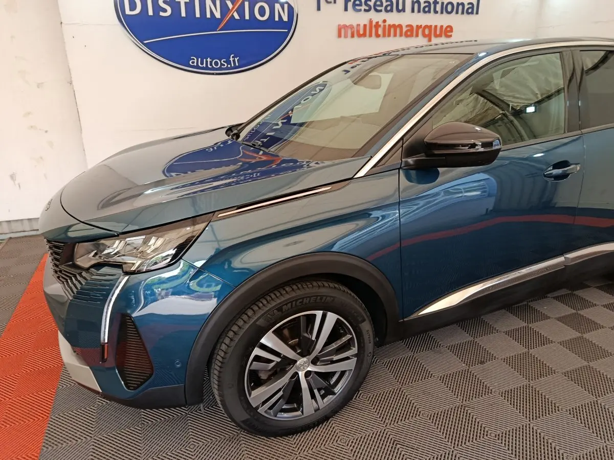 Vue 3/4 avant gauche d'un Peugeot 3008 bleu 2022 avec phares LED et jantes alliage distinctives.