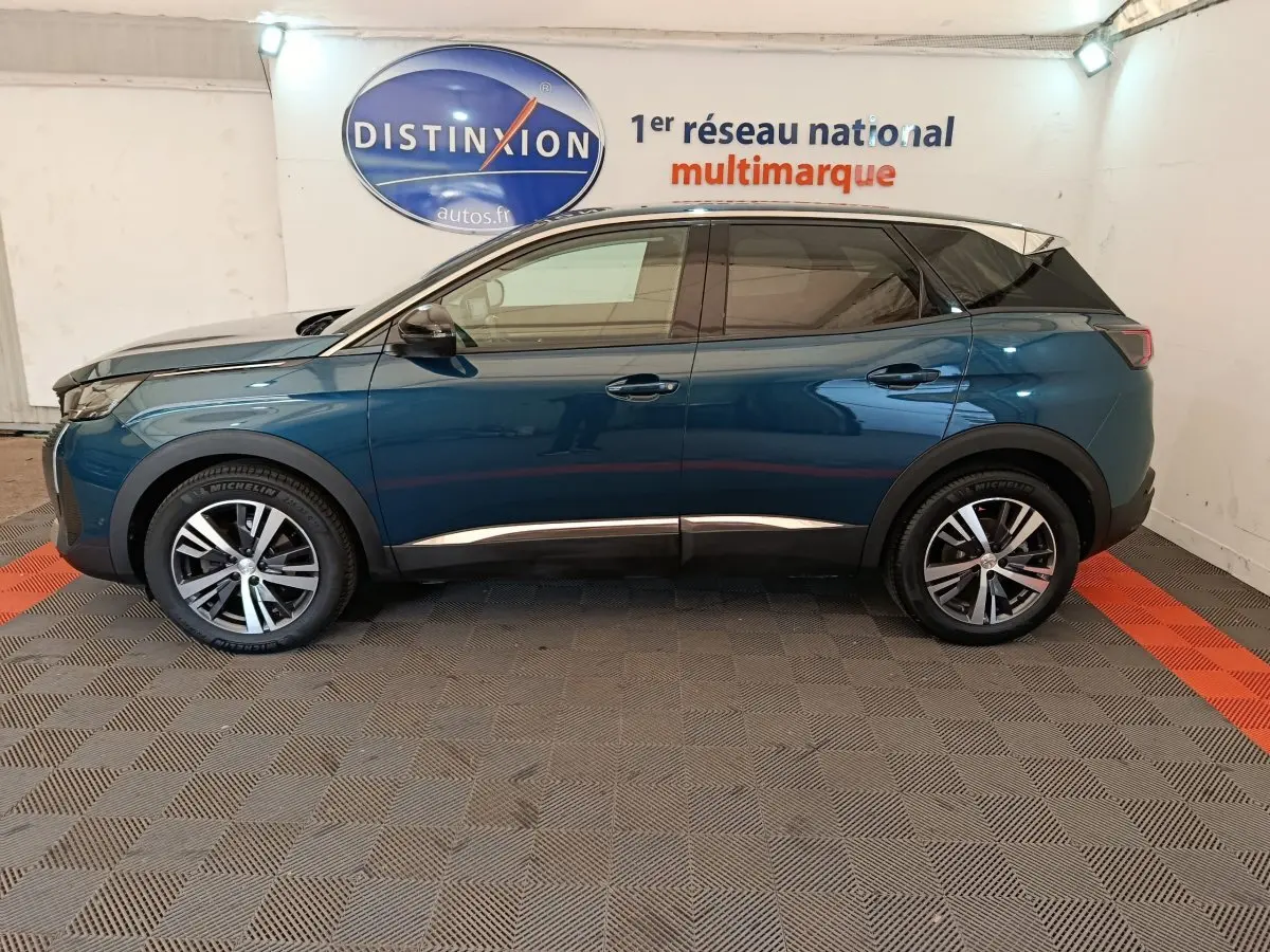 Profil côté gauche d'un Peugeot 3008 PureTech 130 S&S Allure bleu, stationné en intérieur sur sol damier.