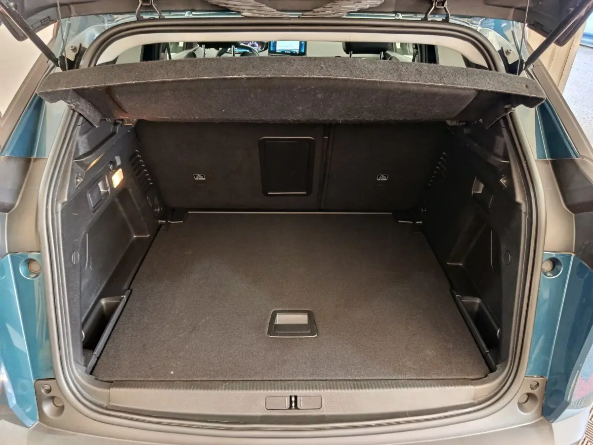 Coffre ouvert vu de l'arrière d'un Peugeot 3008 bleu 2022, montrant un espace de chargement spacieux et propre.