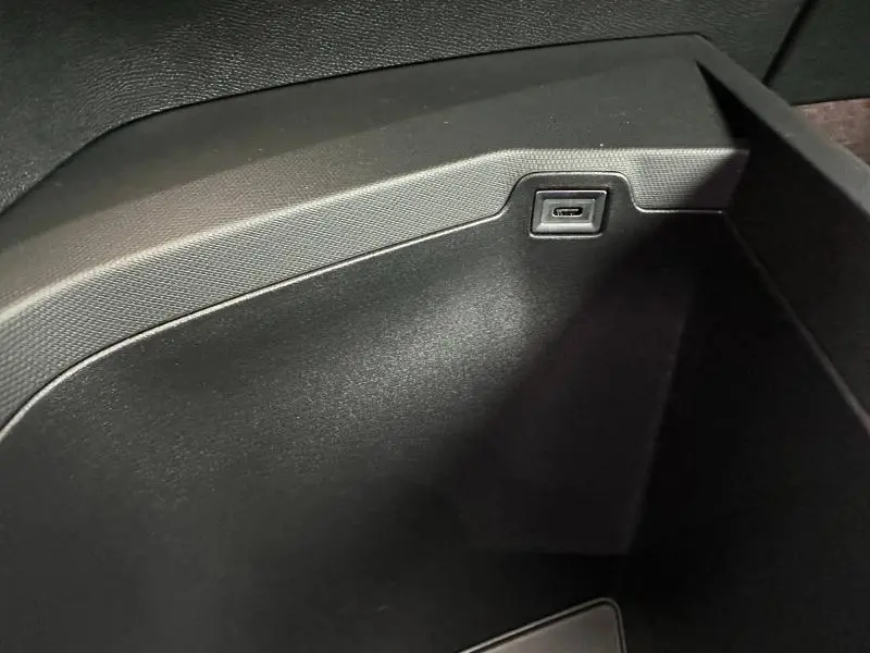Gros plan sur la prise USB intégrée dans le rangement central noir du Peugeot 3008 Hybrid 2025.