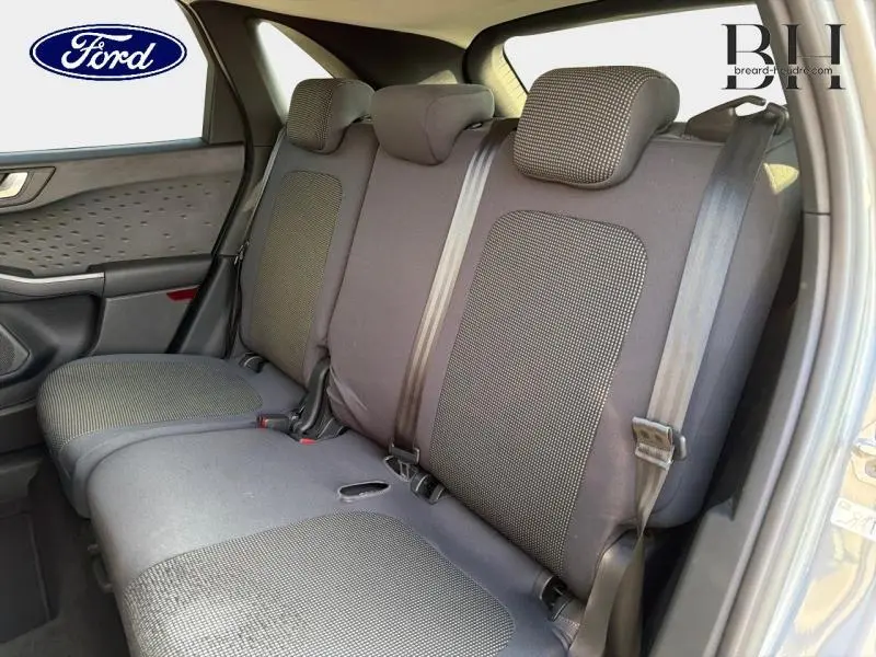Vue intérieure de la banquette arrière du Ford Kuga 2020, tissu noir à motifs, ceintures de sécurité visibles côté droit.