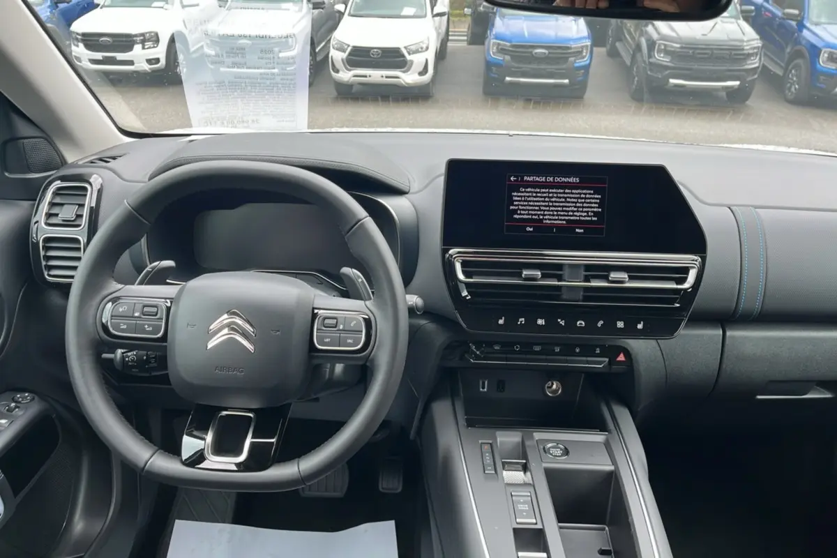 Vue intérieure du tableau de bord et volant cuir multifonctions de la Citroën C5 Aircross blanc okénite 2025.