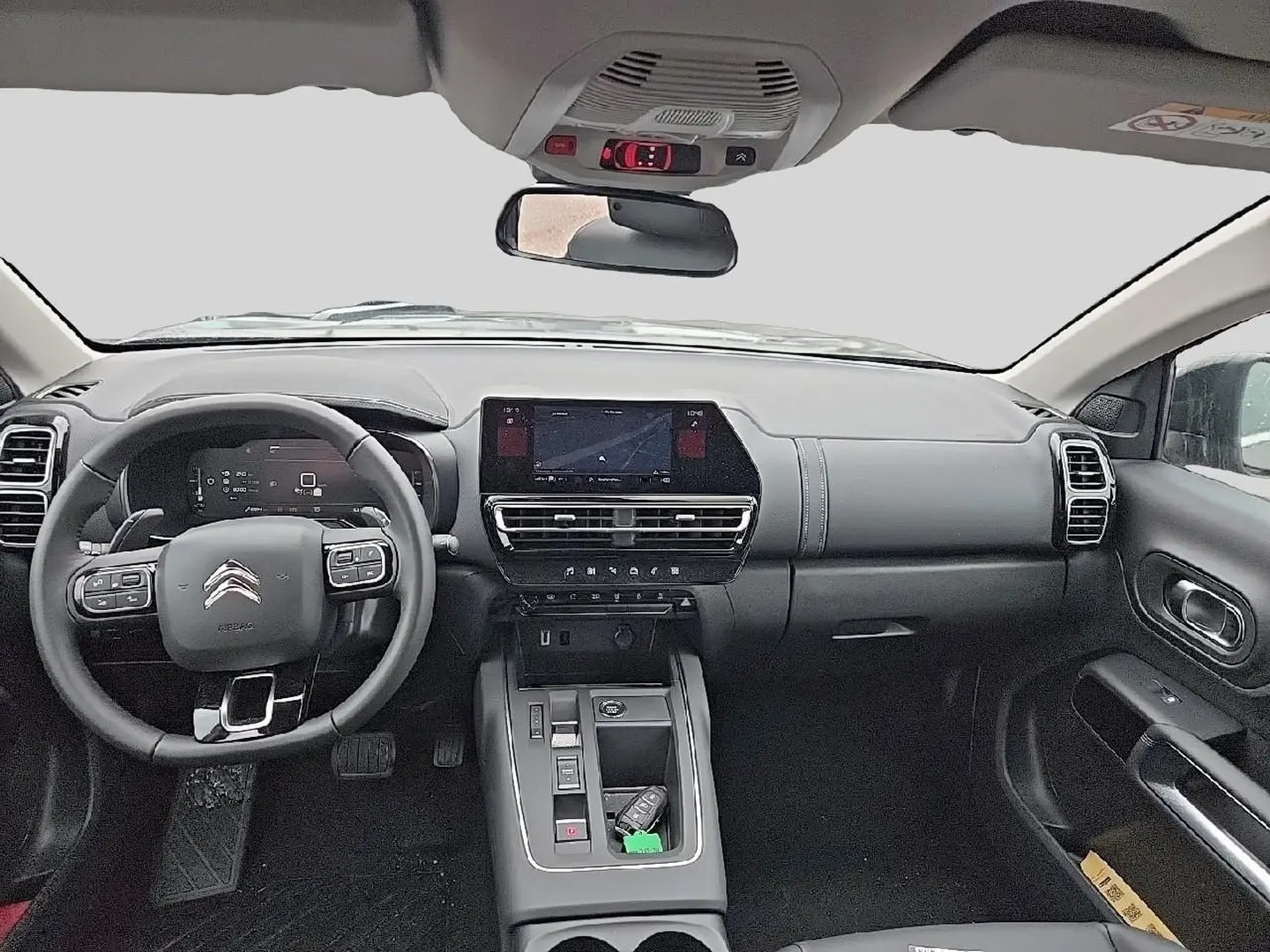 Vue intérieure avant du Citroën C5 Aircross 2025, tableau de bord noir avec écran tactile et volant multifonction cuir.