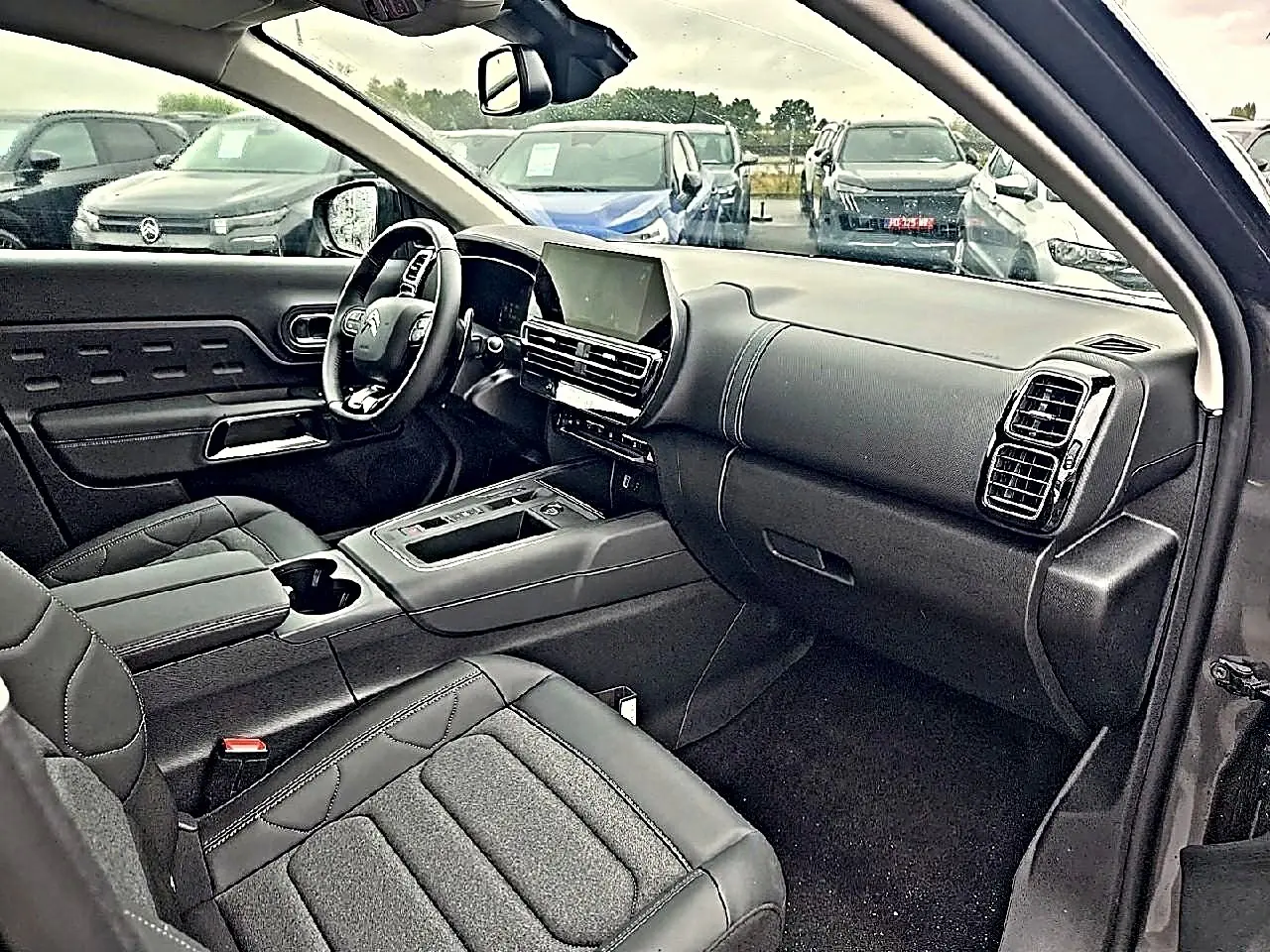 Vue intérieure côté conducteur du Citroën C5 Aircross gris, avec tableau de bord moderne et écran tactile central.