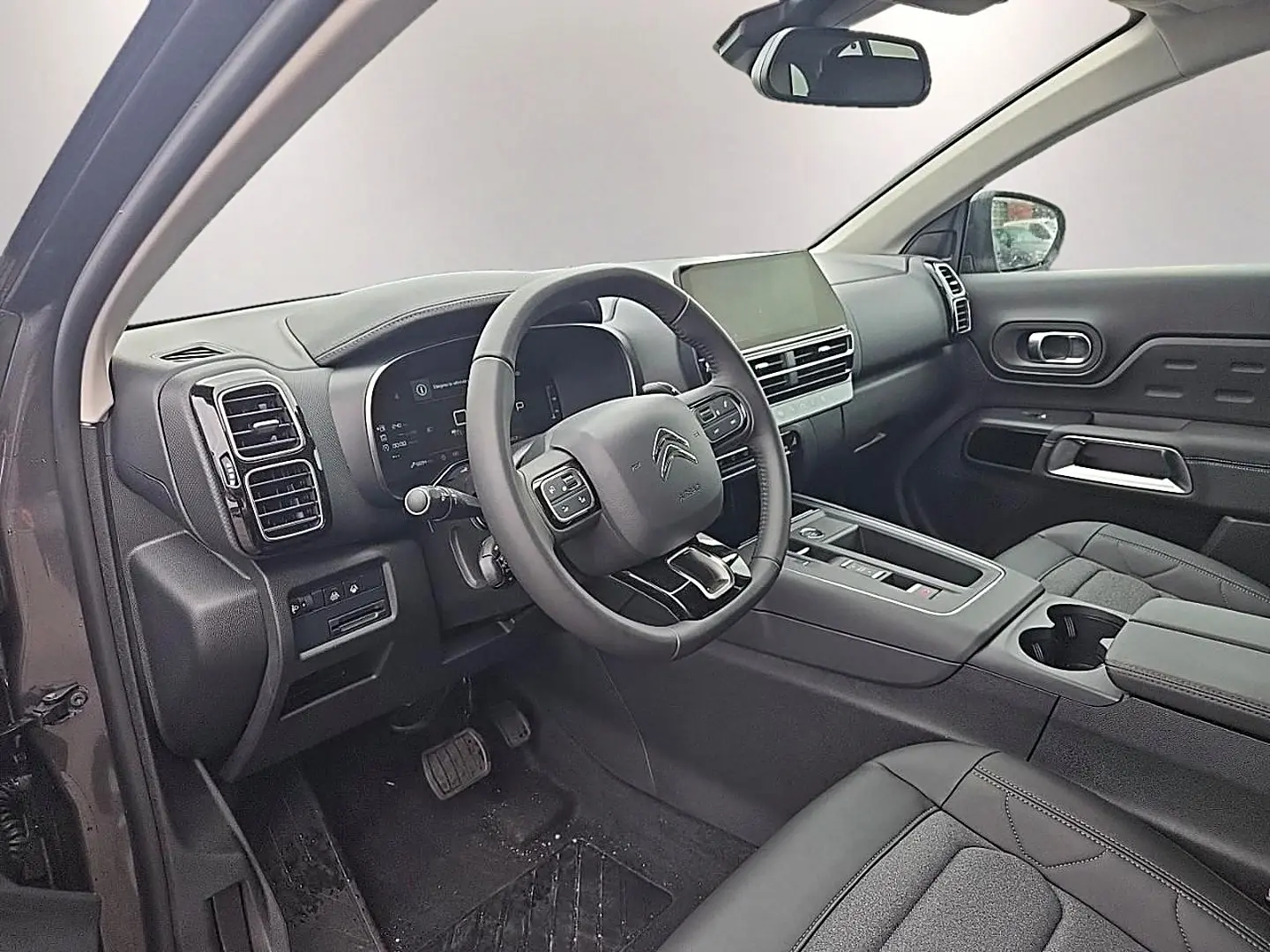 Vue intérieure côté conducteur du Citroën C5 Aircross gris, volant cuir multifonction et écran tactile central visible.