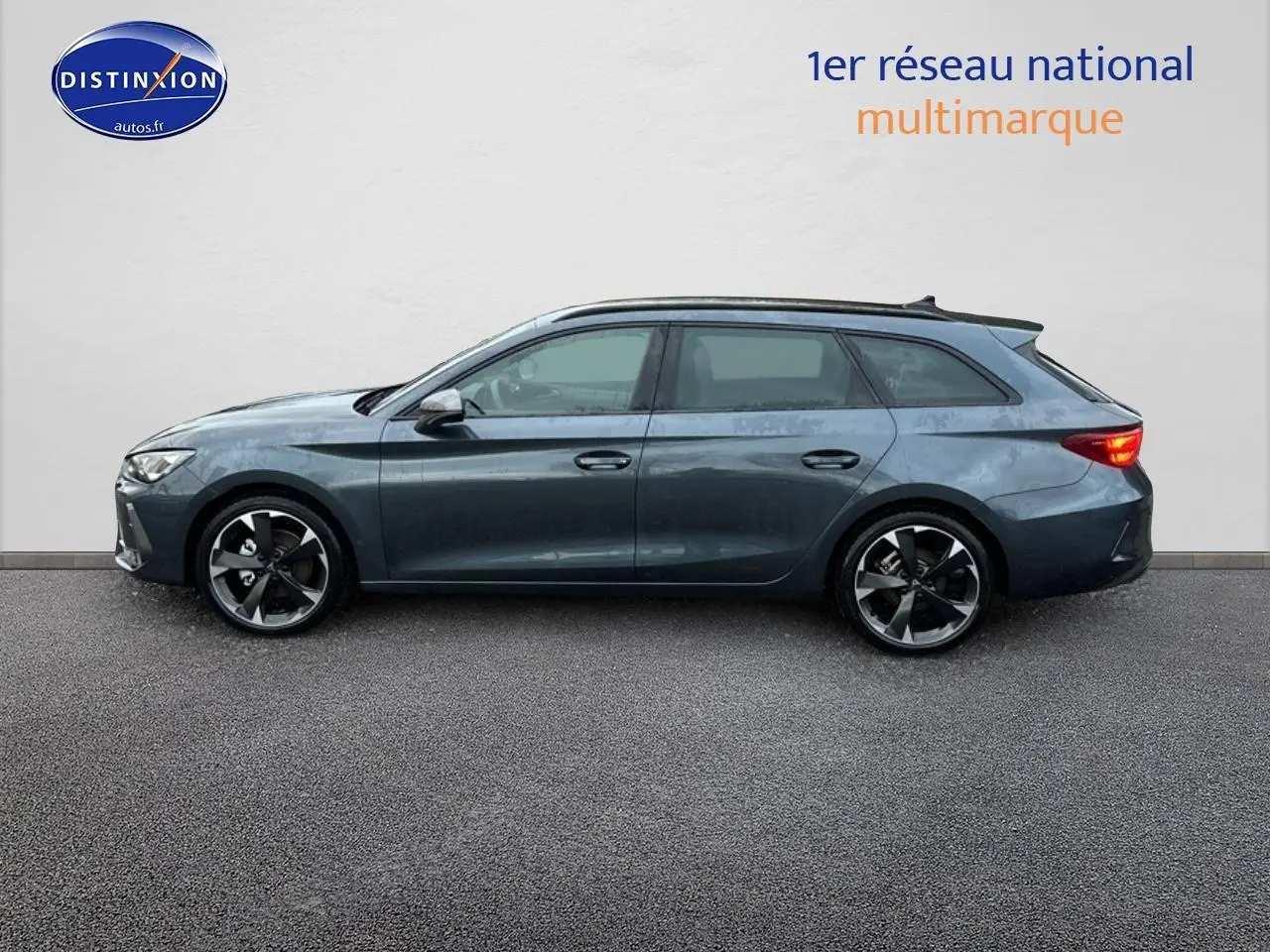 Profil droit d'une CUPRA LEON ST gris magnétique avec jantes alu et feux arrière allumés sur fond neutre.