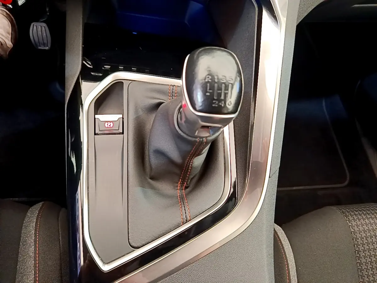 Gros plan sur levier de vitesses manuel et frein électrique dans Peugeot 3008 gris foncé, intérieur tissu noir.