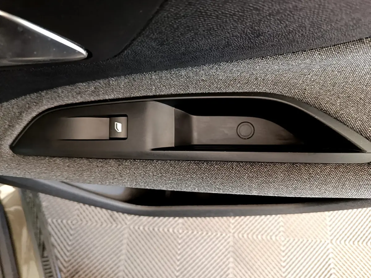 Détail de la commande de lève-vitre sur la porte côté gauche d’un Peugeot 3008 gris foncé 2020.