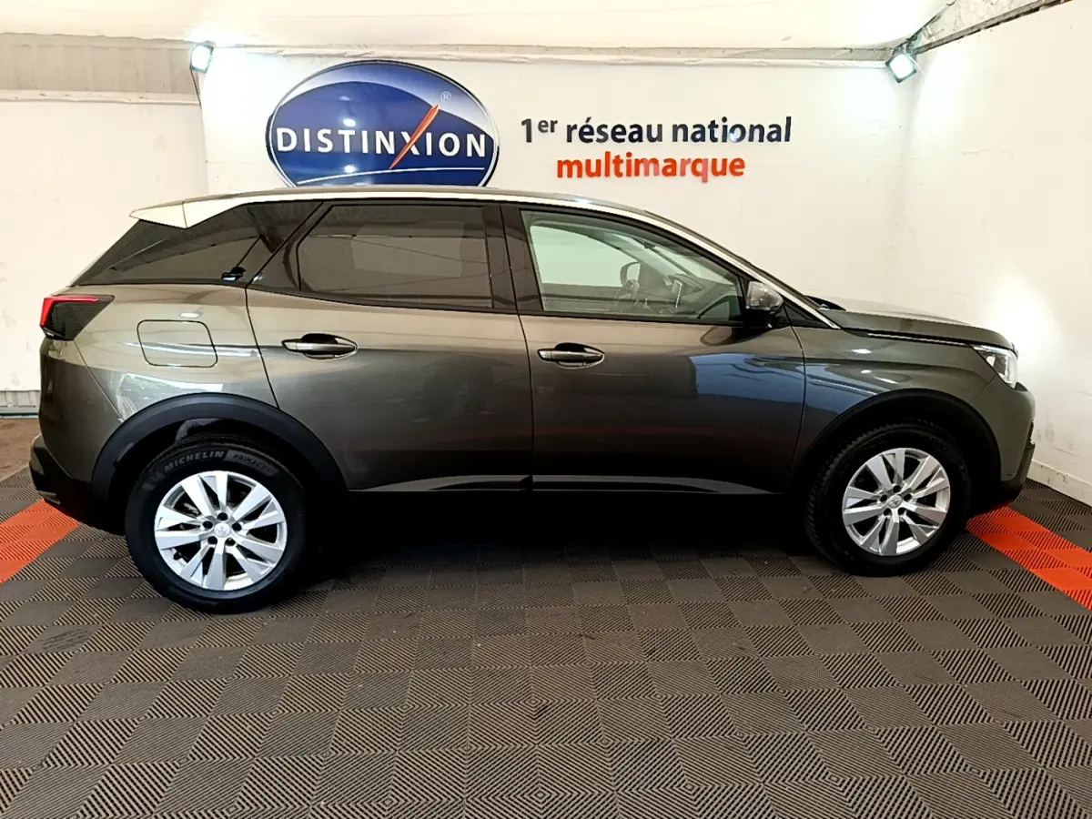 Profil latéral droit d'un Peugeot 3008 gris foncé 2020 dans un showroom avec logo Distinxion en arrière-plan.