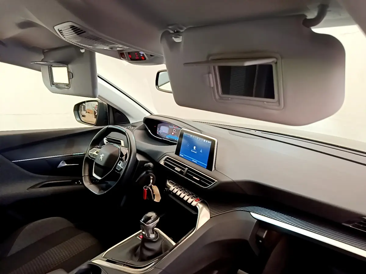 Intérieur de Peugeot 3008 gris foncé, vue côté conducteur, tableau de bord avec écran tactile et volant cuir multifonctions.