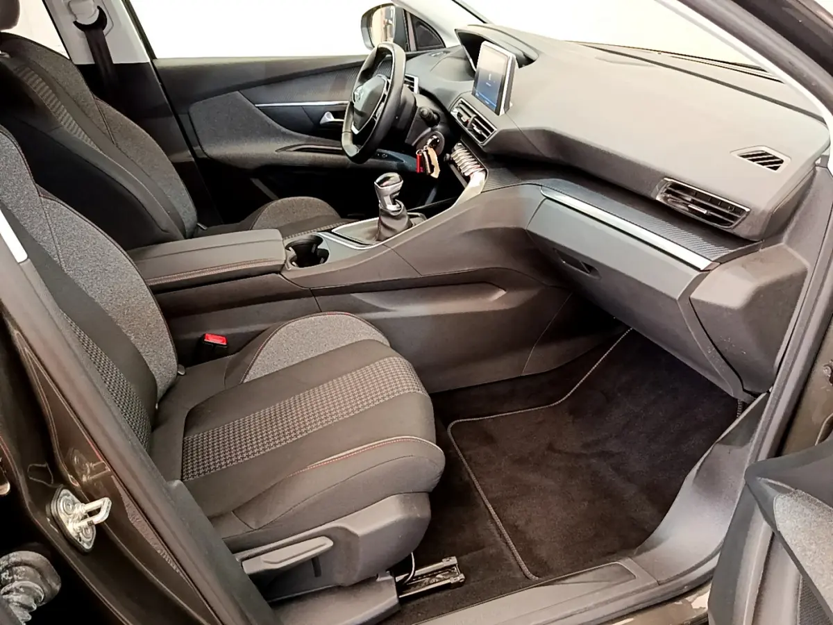 Intérieur avant droit du Peugeot 3008 gris foncé 2020 avec tableau de bord moderne et volant cuir multifonctions.