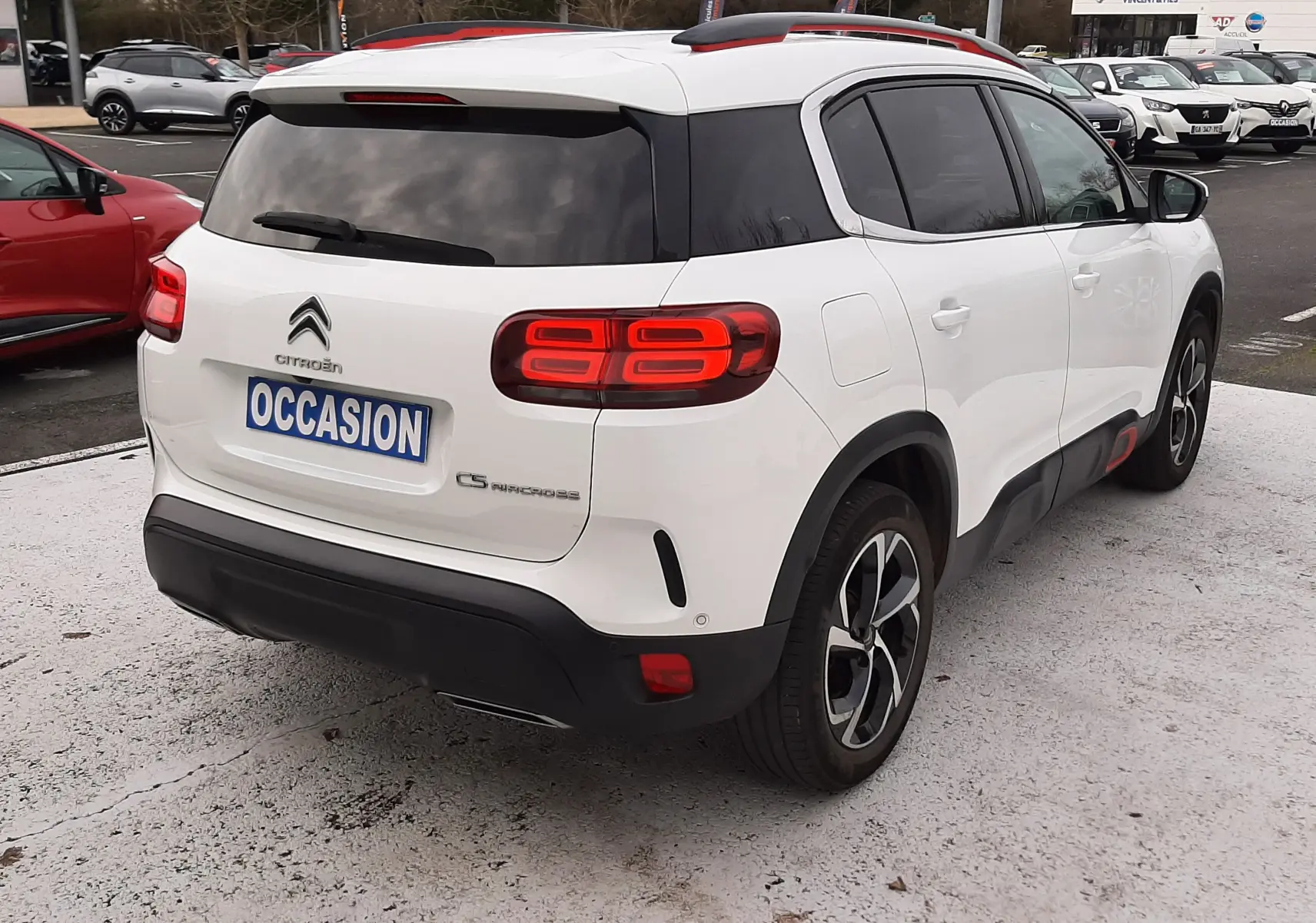 Vue 3/4 arrière droite d'un Citroën C5 Aircross blanc avec toit noir et feux arrière LED distinctifs.