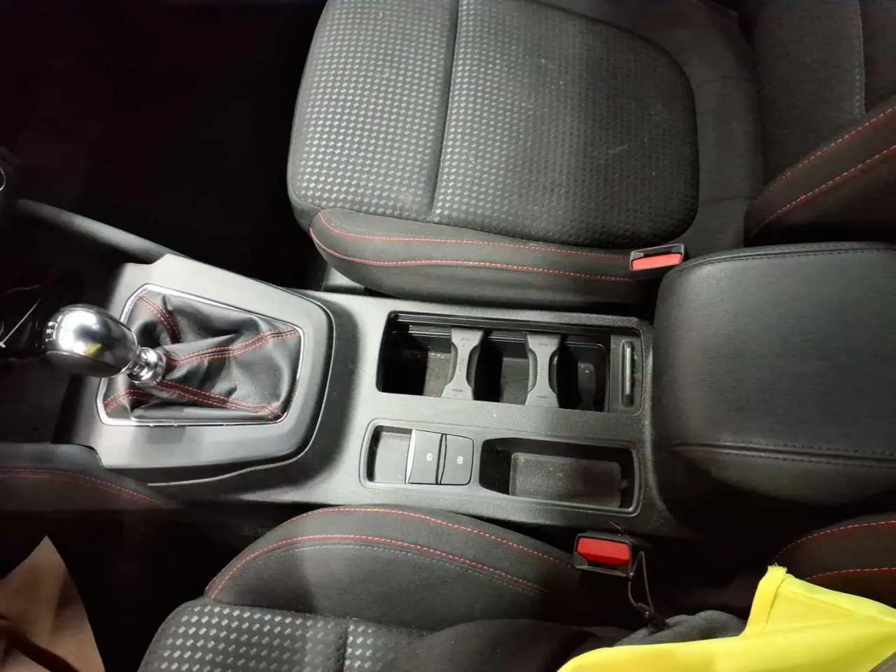 Vue plongeante sur la console centrale et les sièges noirs avec surpiqûres rouges de la Ford Focus SW EcoBoost MHEV 2023.