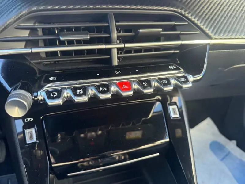 Vue rapprochée de la console centrale noire du Peugeot 2008 Hybrid 136 e-DCS6 Allure avec boutons de commande et aérateurs.
