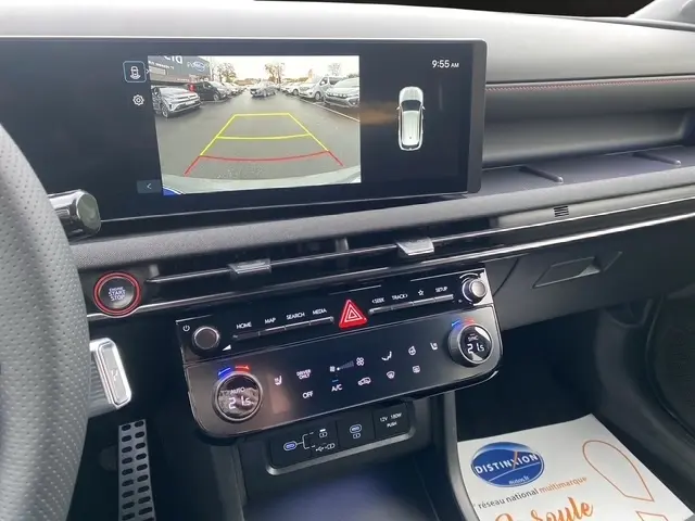 Vue intérieure du tableau de bord du Hyundai Tucson gris foncé 2026, écran de caméra de recul et commandes climatisation tactile.