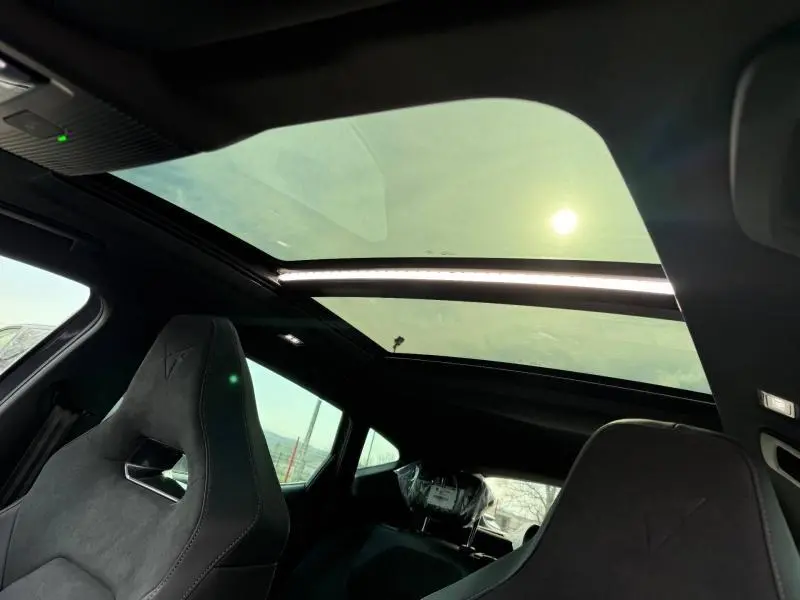 Vue intérieure du CUPRA Formentor 2026 montrant le toit panoramique et les sièges sport en tissu gris foncé.